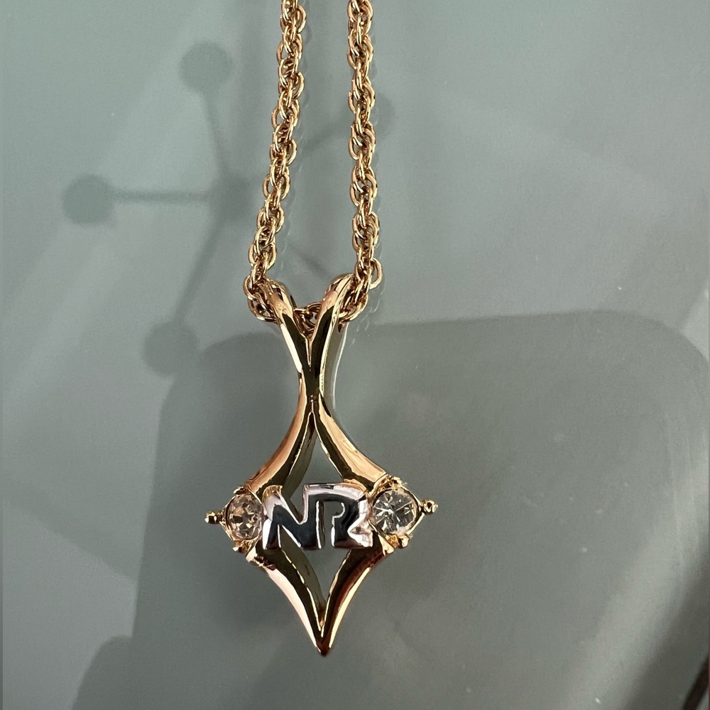 Nina Ricci Vintage necklace with an 'NR' logo pendant and crystal accents.